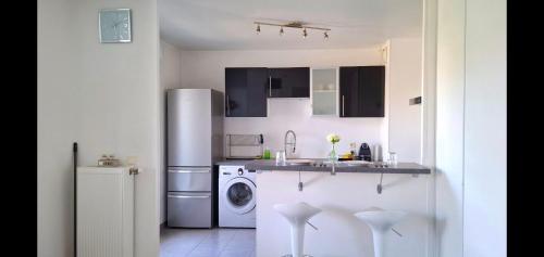 une cuisine avec un réfrigérateur et une machine à laver dans l'établissement Perle centre ville, à Saint-Priest