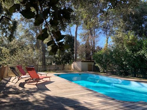 - une piscine avec 2 chaises longues à côté dans l'établissement Villa Natura, à Saint-Jean-de-Cuculles