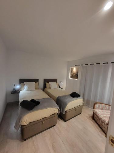 a bedroom with two beds and a couch at Piso céntrico de 3 habitaciones con terraza y vistas in Girona