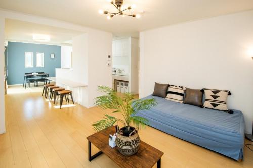 a bedroom with a large bed and a living room at ちゅらパレス c in Urasaki