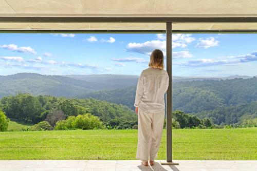 a woman looking out of a window at a field at Panorama Farm - 1BD Sunrise Retreat in Bald Knob