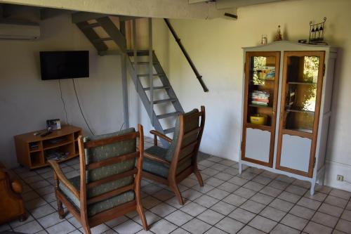 une chambre avec deux chaises, un escalier et une télévision dans l'établissement Les écuries d'Ailly, à La Celle-sous-Gouzon