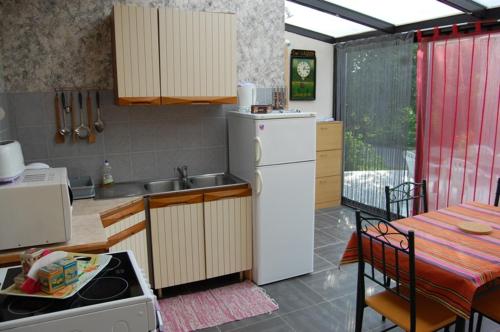 une cuisine avec un réfrigérateur blanc et une table dans l'établissement Les écuries d'Ailly, à La Celle-sous-Gouzon