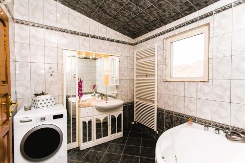 a bathroom with a sink and a toilet and a tub at Villa Almas with swimming pool, tennis court, sauna, gym, grill house in Neorić