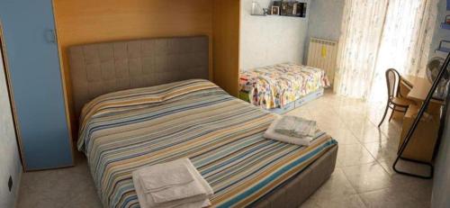 a small bedroom with a bed and a chair at La casa del fiore in Campomarino