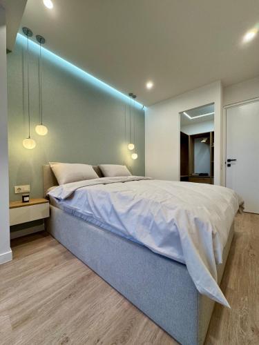 a bedroom with a large bed with a blue wall at Apartment on Charents Street in Sari Tʼag