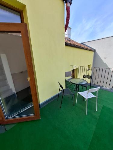 a patio with a table and chairs on a balcony at útulný podkrovní byt v centru Třebíče in Třebíč