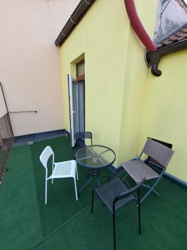 a patio with chairs and a glass table and chairs at útulný podkrovní byt v centru Třebíče in Třebíč