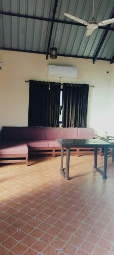 a living room with a table and pink couch at THE HEART OF HEAVEN in Āmbavna
