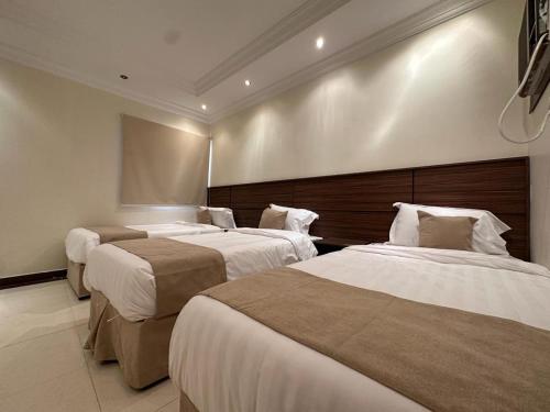 a room with three beds in a hotel room at شقق منارا المدينة - Mnara Al-Madinah Apartments in Al Madinah