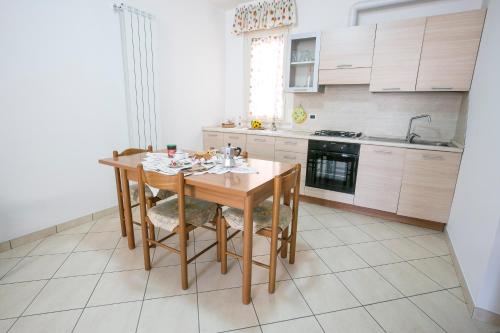 una cucina con tavolo e sedie in legno di Leopardi Pineto Vacanza a Pineto