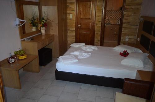 a bedroom with a large white bed and a desk at Penzion Blo in Panormos Skopelos