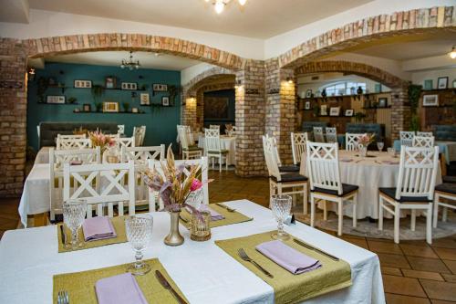 a dining room with white tables and white chairs at Porto Resort in Lilaste