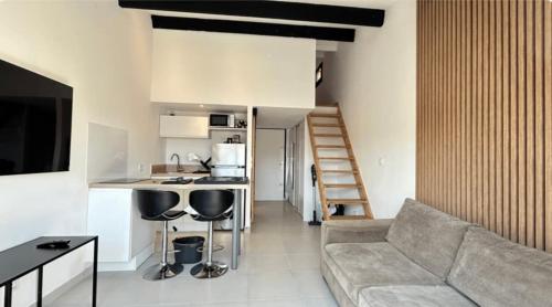 un salon avec un canapé et une cuisine dans l'établissement Appartement en résidence, au Cap d'Agde