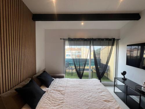 une chambre avec un lit et une grande fenêtre dans l'établissement Appartement en résidence, au Cap d'Agde
