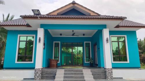 a house with a blue facade at Dee Riverside Homestay airport kota Bharu in Kota Bharu