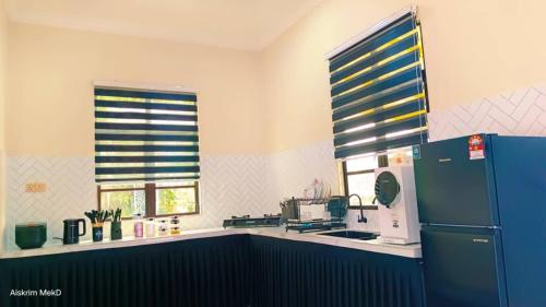 a kitchen with a blue refrigerator in a kitchen at Dee Riverside Homestay airport kota Bharu in Kota Bharu