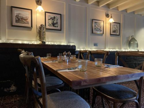 a dining room with a wooden table and chairs at The Forresters Arms Kilburn in Kilburn