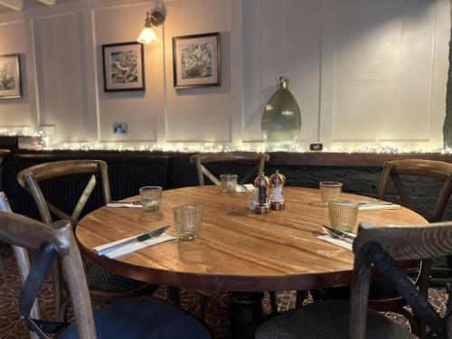 a wooden table in a restaurant with glasses on it at The Forresters Arms Kilburn in Kilburn
