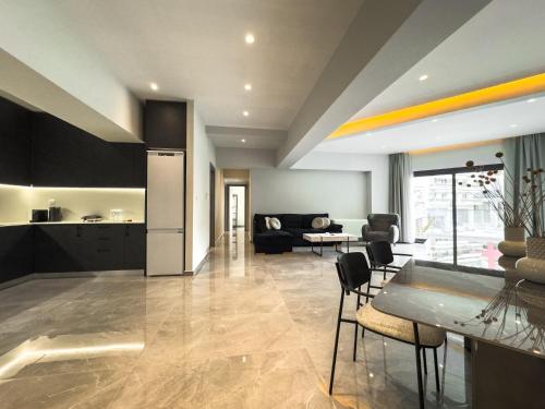 a kitchen and a living room with a table and chairs at VILLA 8 By ProLiving Hospitality in Thessaloniki