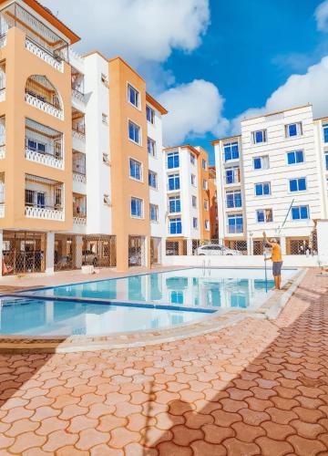 an apartment complex with a swimming pool and buildings at Luxury holiday apartments in Mombasa