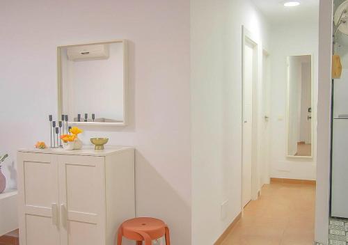 a white room with a mirror and a stool at MojacarProperty Noalejo Beach Apartment in Mojácar