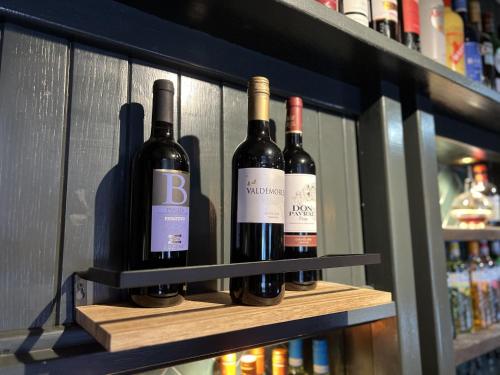 four bottles of wine on a shelf in a store at The Forresters Arms Kilburn in Kilburn