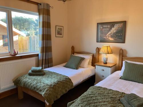 a bedroom with two beds next to a window at Cosy Holiday Home Portpatrick in Portpatrick