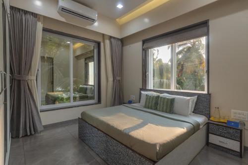 a bedroom with a bed and a large window at SaffronStays Skylight in Alibaug