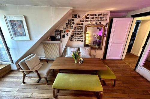 une salle à manger avec une table et des chaises et un escalier dans l'établissement Appartement 74m2 in the center of Paris, à Paris