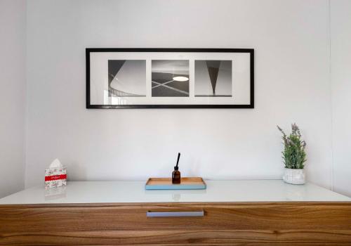 a mirror on a white wall above a wooden dresser at Mavisbank Gardens in Glasgow