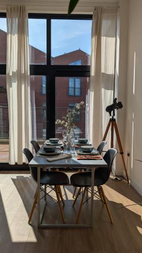a dining room with a table and chairs and a large window at Tranquil & Bright by The Canal in London