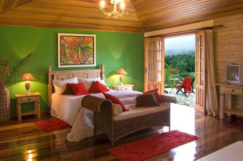 um quarto com uma cama e uma parede verde em Pousada Recanto do Pinheirão em Visconde de Mauá