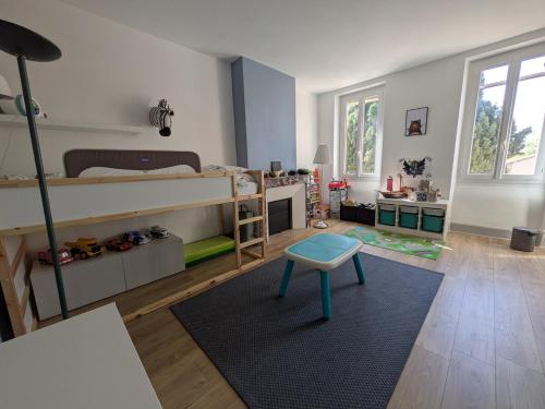 - une chambre avec des lits superposés et un tabouret bleu dans l'établissement Maison de Maître Toulousaine avec piscine, à Lavernose