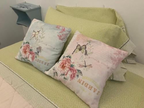 - 2 oreillers avec des papillons installés sur un lit dans l'établissement Romantic Chic Loä, à Loano
