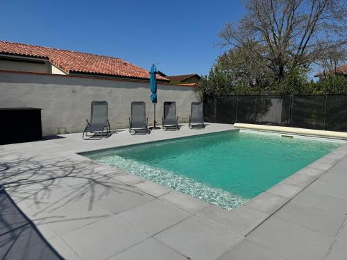 - une piscine avec 4 chaises dans l'établissement Maison de Maître Toulousaine avec piscine, à Lavernose