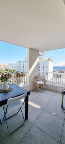 un balcon avec une table et une chaise sur un immeuble dans l'établissement Appartement centre ville - moderne - T2, à Montpellier