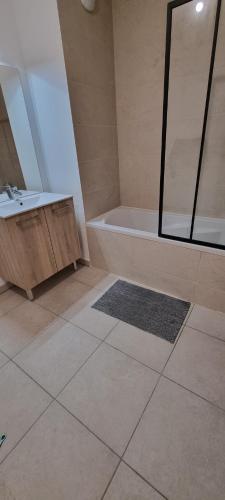 une salle de bain avec une baignoire et un lavabo dans l'établissement Appartement centre ville - moderne - T2, à Montpellier