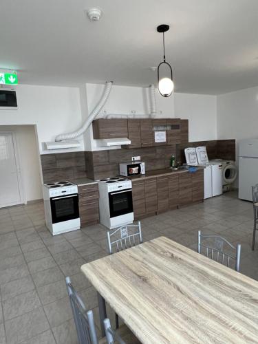 a large kitchen with a table and chairs and a counter at Dream Home in Szentes