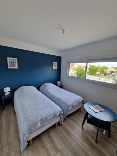 ein Schlafzimmer mit zwei Betten und einem Fenster in der Unterkunft Maison plain-pied 4 chambres Graye sur mer plage à 700 m in Graye-sur-Mer