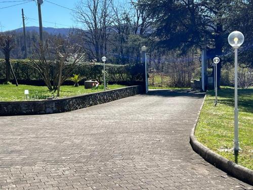 a brick walkway with street lights in a park at Casa del Sindaco in Giusvalla