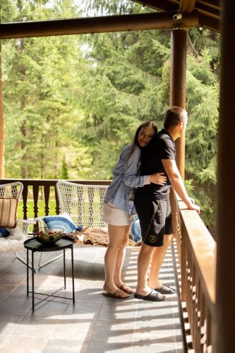 a man and a woman standing on a porch at Маєток Ліс і Гори in Bukovel