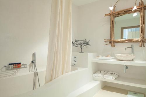 a white bathroom with a sink and a mirror at Hotel Es Marès in Sant Francesc Xavier