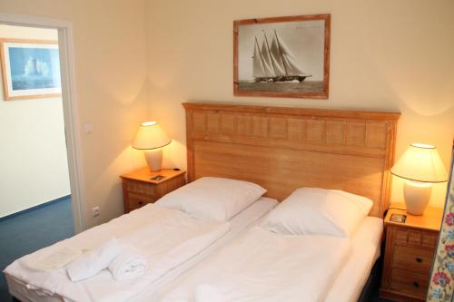 2 Betten in einem Schlafzimmer mit zwei Lampen auf beiden Seiten in der Unterkunft Apartment am Großen Plöner See in Ascheberg