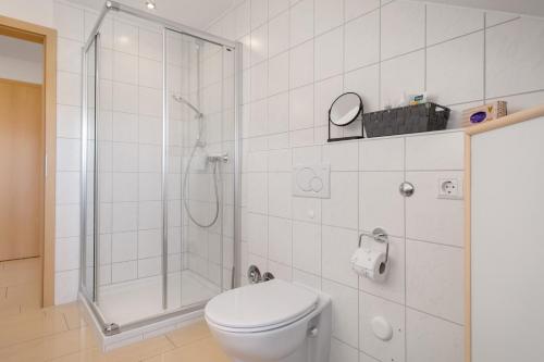 a white bathroom with a toilet and a shower at Bergchalet Mirabell - Hofgut in Friedrichshafen