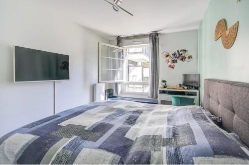 une chambre avec un lit et une télévision à écran plat dans l'établissement Charming apartment, à Garches