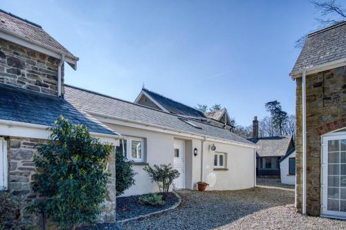 a white house with a driveway in front of it at The Studio - 1 Bedroom Cottage - Princes Gate in Ludchurch
