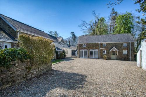 a large brick house with a stone driveway at The Studio - 1 Bedroom Cottage - Princes Gate in Ludchurch