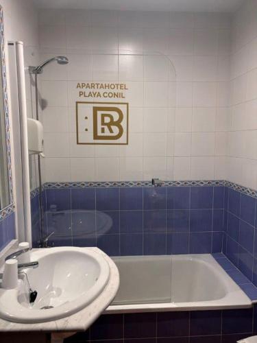 a bathroom with a bath tub and a sink at Apartahotel Rompeolas in Conil de la Frontera