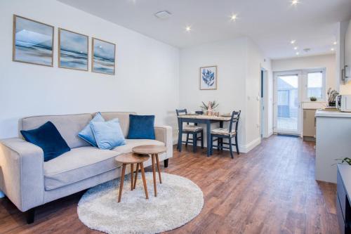a living room with a couch and a table at The Studio - 1 Bedroom Cottage - Princes Gate in Ludchurch